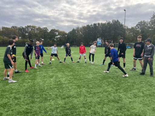 kinderen op het voetbalveld rekken en strekken