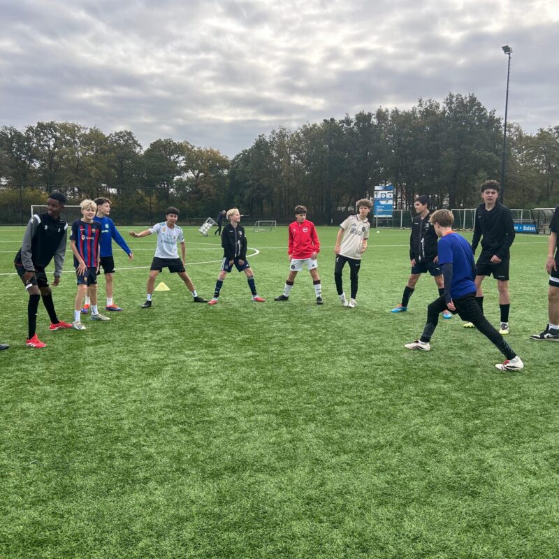 kinderen op het voetbalveld rekken en strekken
