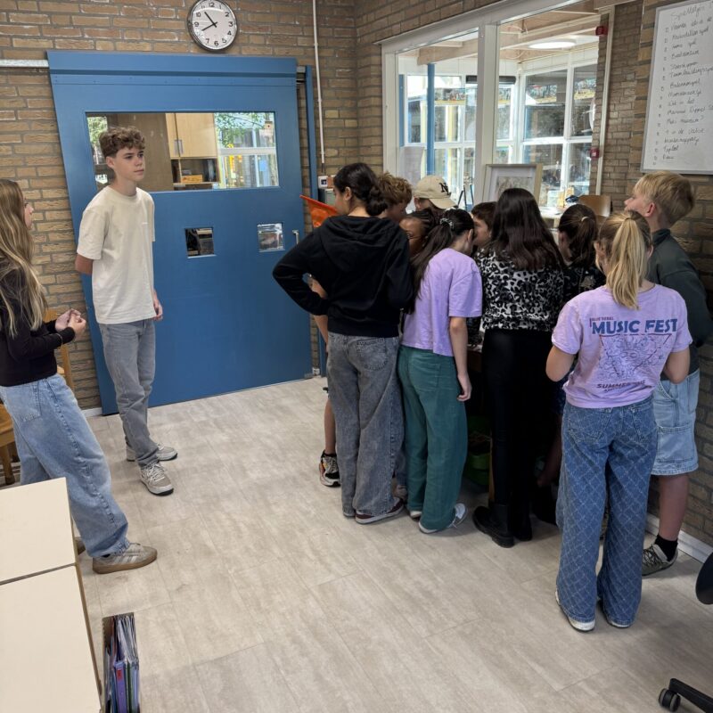 Leerlingen geconcentreerd rond een opdracht in de klas