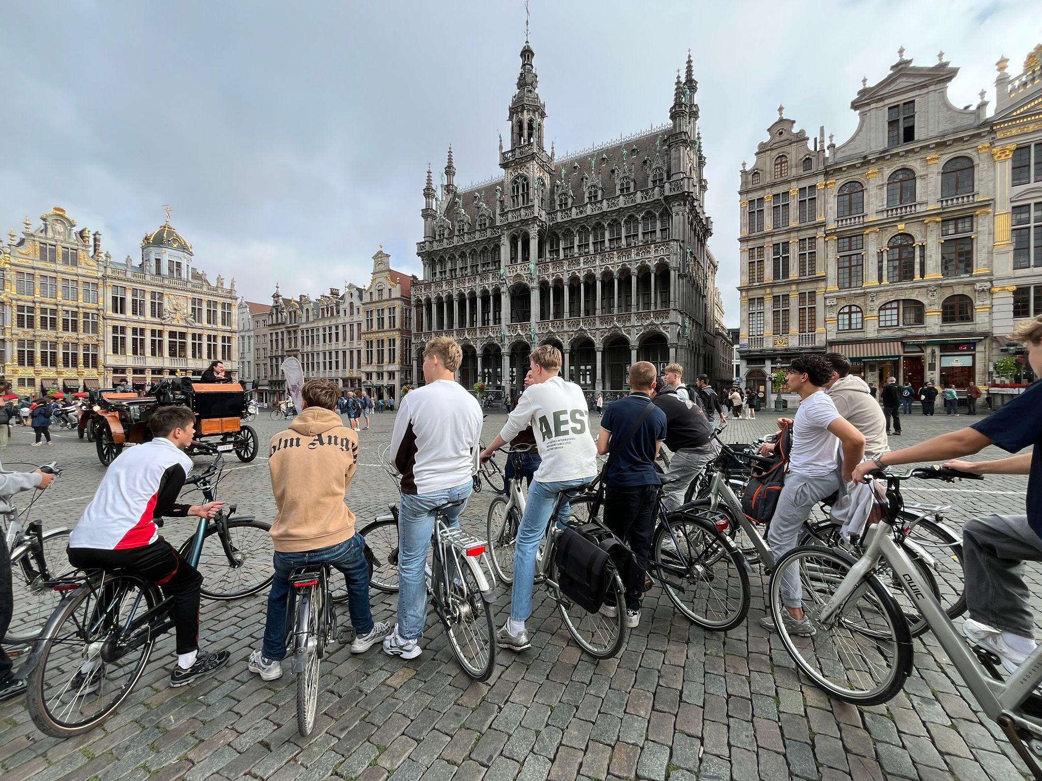 Groep jongens met fietsen op de Grote Markt in Brussel
