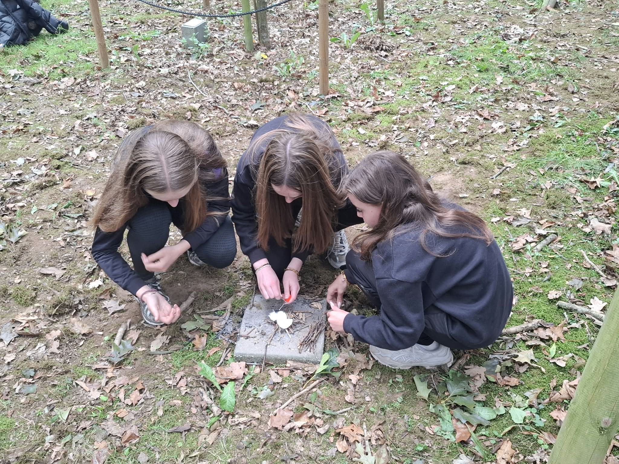 Drie meisjes proberen vuur te maken