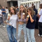 Drie leerlingen eten een ijsje