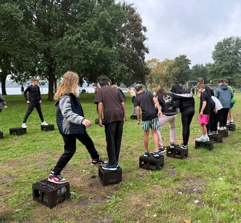 Kinderen dragen kratten aan elkaar over