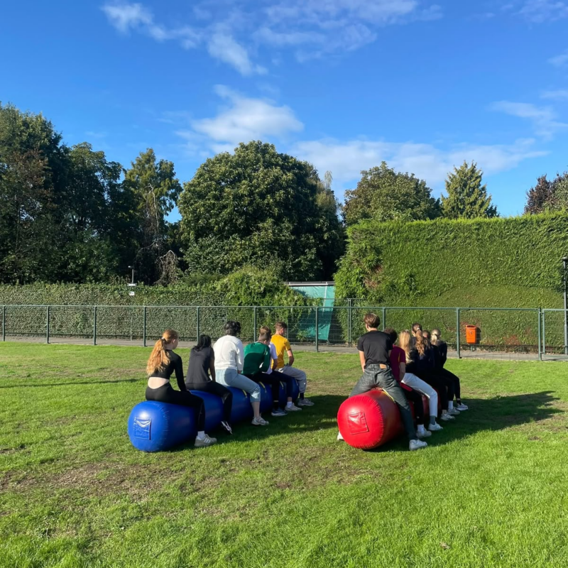 Een groep leerlingen die op twee opblaasballen zit.